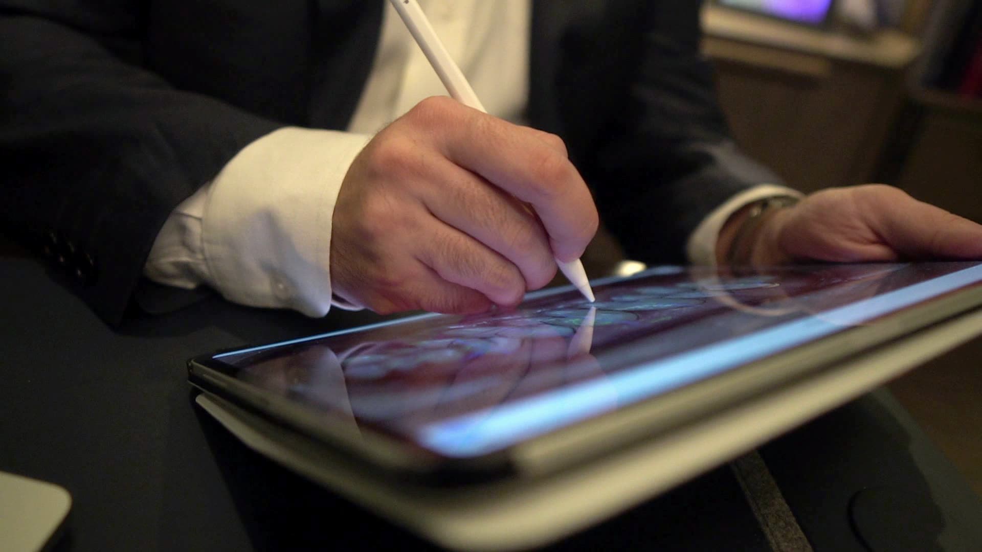 Dr. Atassi sketching a smile design on an iPad with a stylus