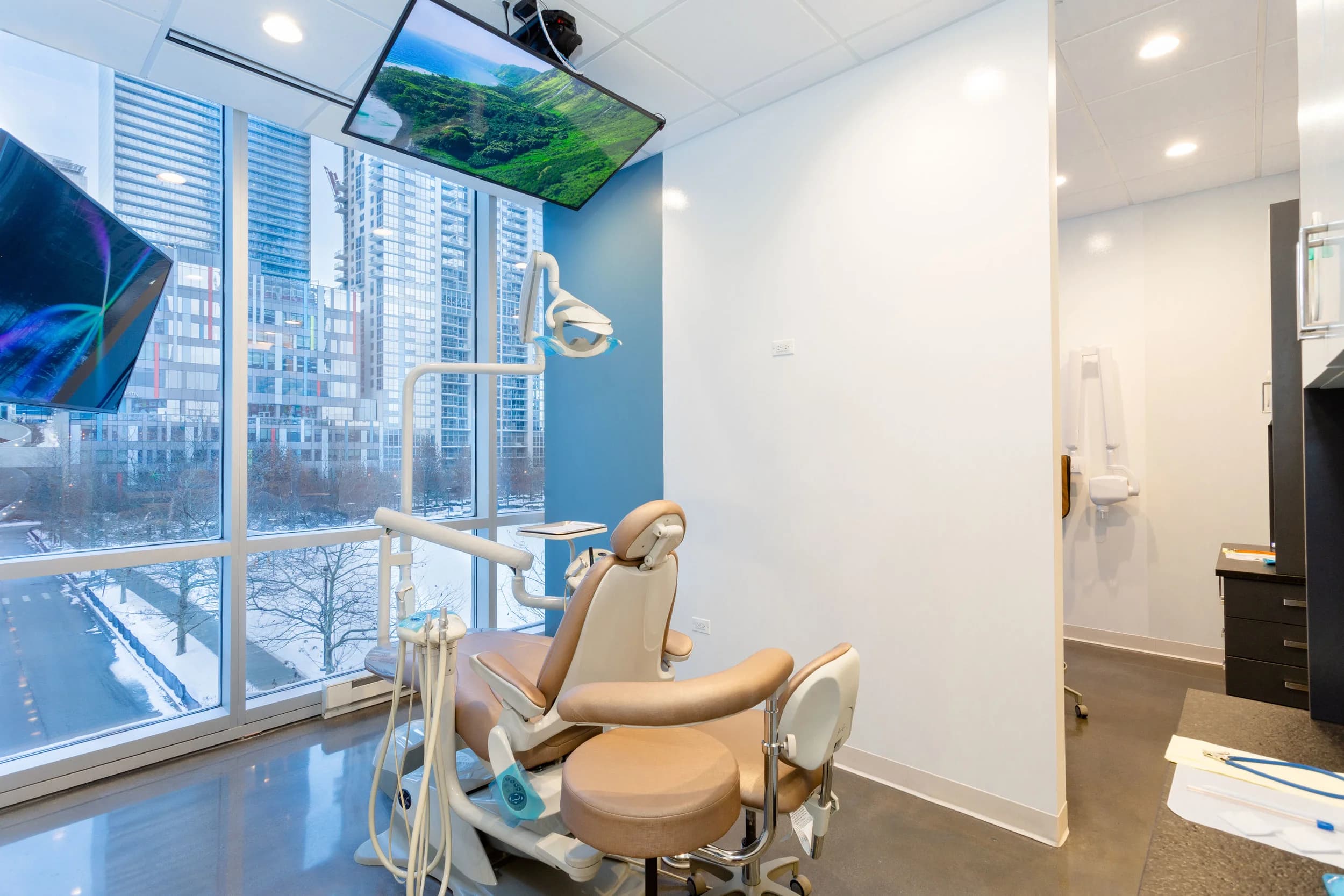 A treatment room with the screen overhead and the skyline beyond the glass